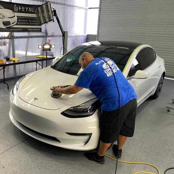 person polishing hood of tesla car